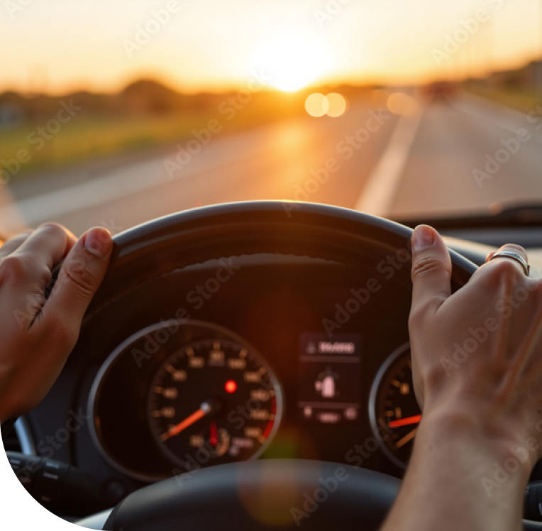 Persona alla guida di un'auto al tramonto